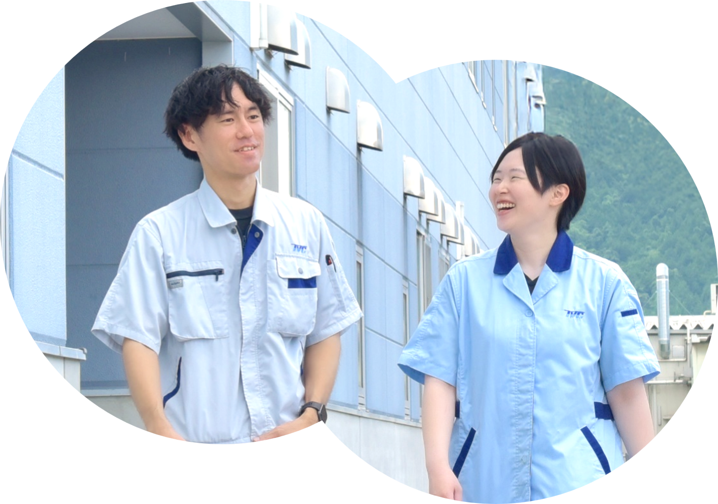 スーツを着た男女が青空の下で笑いあっている写真